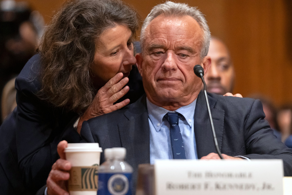 Secretary of Health and Human Services Robert F. Kennedy Jr., listens as Principal Deputy Chief of Staff Stefanie Spear speaks to him during a hearing the Senate Finance Committee, on Capitol Hill in Washington, Thursday, Sept. 4, 2025. (AP Photo/Mark Schiefelbein)