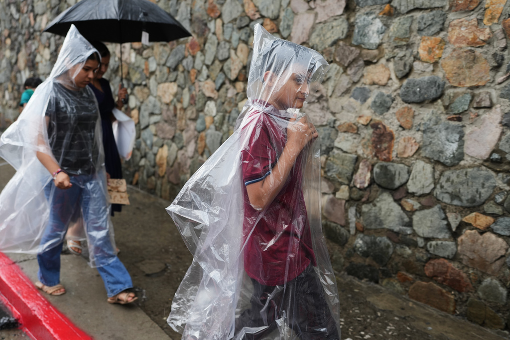 Ederson Galicia Alva, right, walks with his mother, Mirsy Maricela Alva López, and sister, Briseidy, through the historic center of Guatemala City, Wednesday, May 27, 2026. (AP Photo/Moises Castillo)