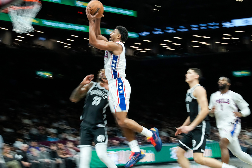 Philadelphia 76ers' Quentin Grimes, second from left, jumps to the basket against Brooklyn Nets' Nic Claxton (33) during the second half of an NBA basketball game Sunday, Nov. 2, 2025, in New York. (AP Photo/Eduardo Munoz Alvarez)