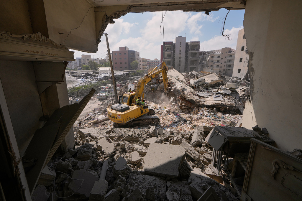 Rescue workers use an excavator, as they search for victims under the rubble of a building that was hit Monday in an Israeli airstrike in the southern port city of Tyre, Lebanon, Tuesday, June 2, 2026. (AP Photo/Mohammed Zaatari)