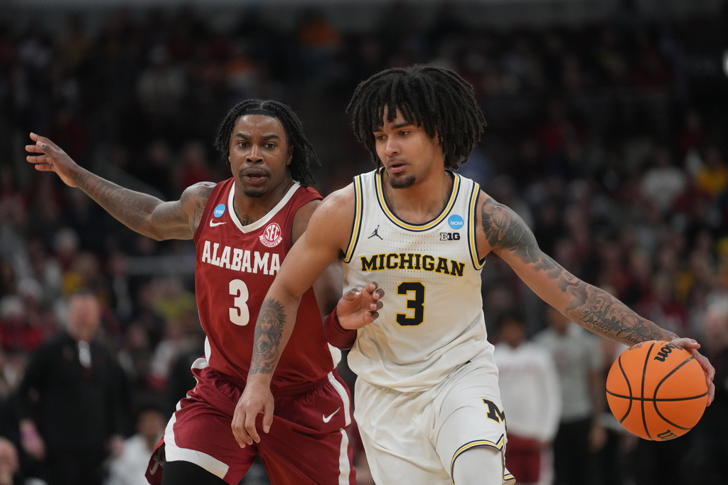 Michigan's Elliot Cadeau, right, drives past Alabama's Latrell Wrightsell during the second half in the Sweet 16 of the NCAA college basketball tournament, Friday, March 27, 2026, in Chicago. (AP Photo/Erin Hooley)