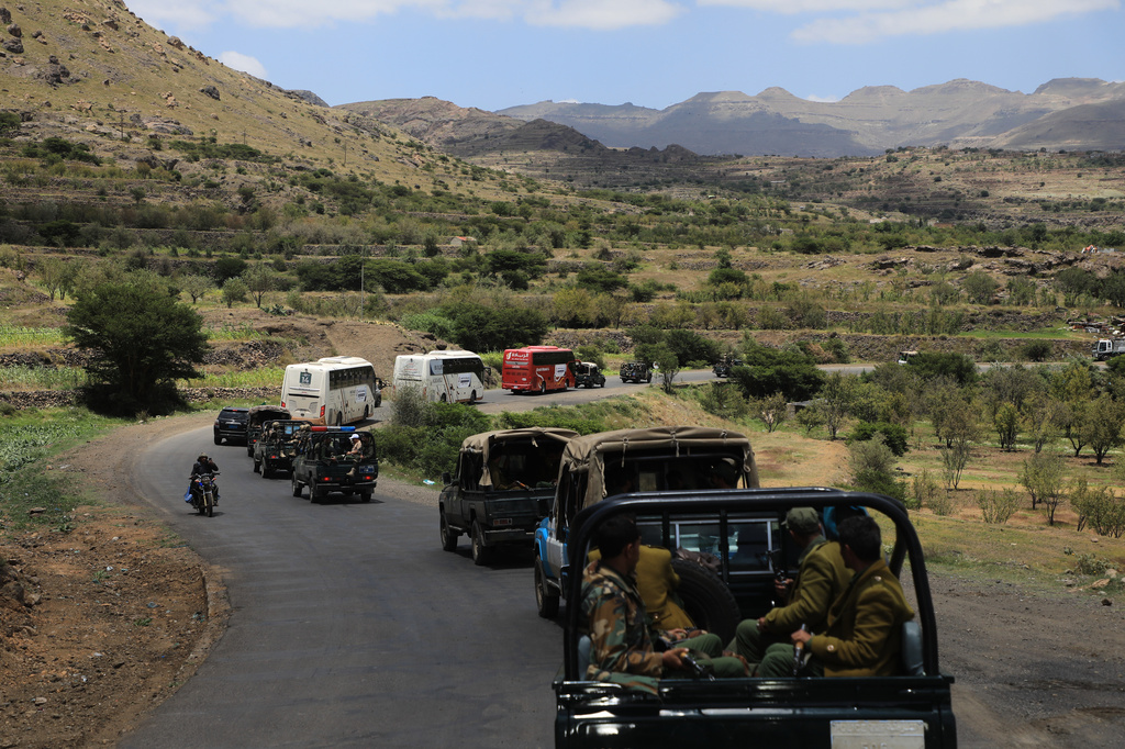 Houthi fighters escort a convoy carrying prisoners freed in Mokha through the Bani Matar district on its way to Sanaa, Yemen, Saturday, Sept. 12, 2026, following the Houthi takeover of the southern Red Sea port city. (AP Photo/STR)