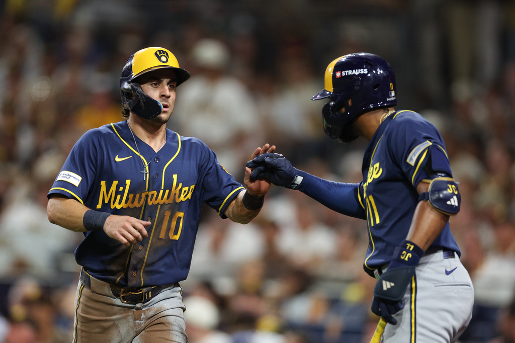 Milwaukee Brewers' Sal Frelick (10) is congratulated by Jackson Chourio after scoring on a single by Garrett Mitchell during the third inning in Game 4 of baseball's National League Division Series against the San Diego Padres Wednesday, Oct. 7, 2026, in San Diego. (AP Photo/Derrick Tuskan)