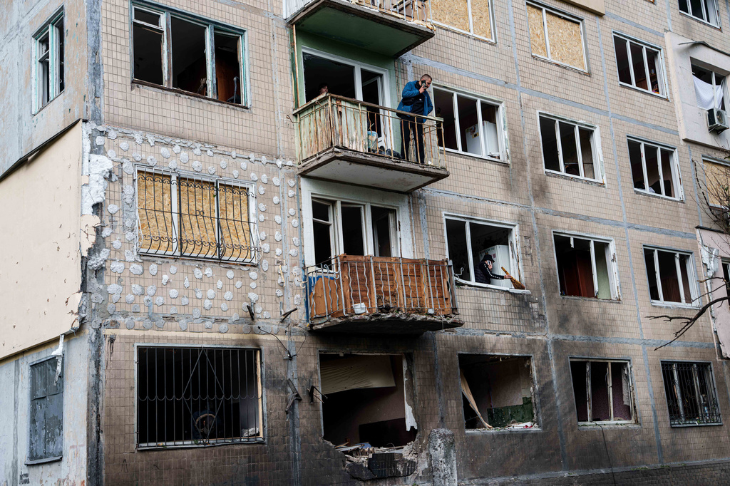 A man stands at a balcony of an apartment building damaged after a Russian drone strike in Kyiv, Ukraine, on Tuesday, Sept. 22, 2026. (AP Photo/Evgeniy Maloletka)