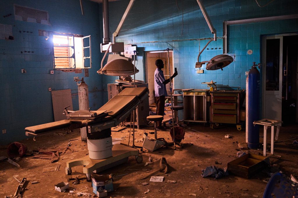 A guard walks through a war-damaged section of Al Shaabi Hospital in Khartoum, Sudan, Saturday, April 18, 2026. (AP Photo/Bernat Armangue)