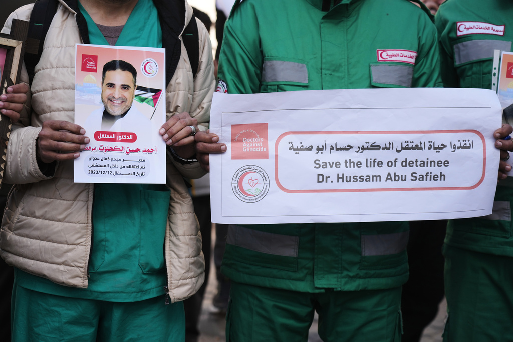Medical staff take part in a protest organized by the Palestinian Prisoners Committee calling for the release of prisoners held in Israeli prisons outside the Red Cross headquarters in Gaza City Monday, Jan. 12, 2026. (AP Photo/Jehad Alshrafi)