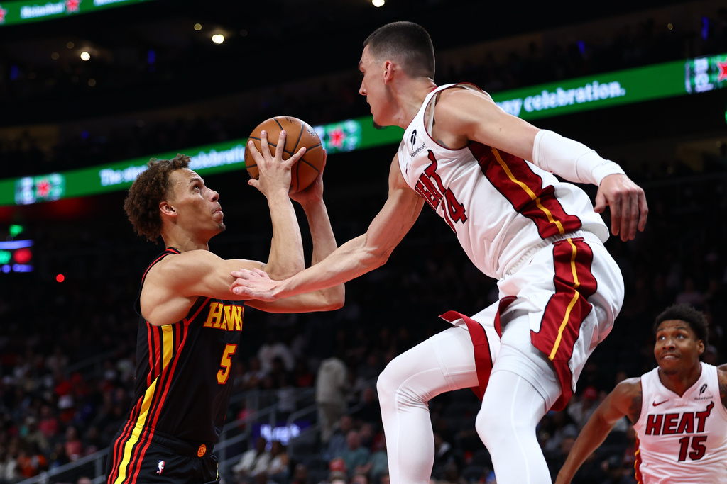 Atlanta Hawks guard Dyson Daniels (5) shoots against Miami Heat guard Tyler Herro, right, during the first half of an NBA basketball game, Friday, Feb. 20, 2026, in Atlanta. (AP Photo/Colin Hubbard)