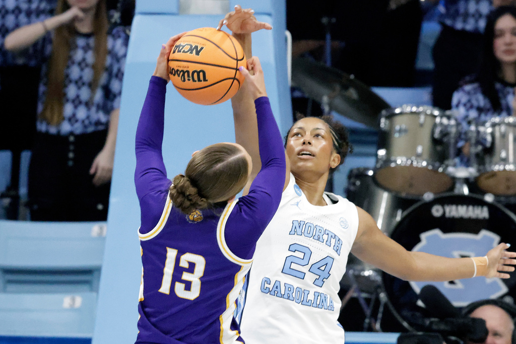 Western Illinois guard Addi Brownfield (13) is defended by North Carolina guard Indya Nivar (24) during the first half in the first round of the NCAA college basketball tournament, Friday, March 20, 2026, in Chapel Hill, N.C. (AP Photo/Chris Seward)