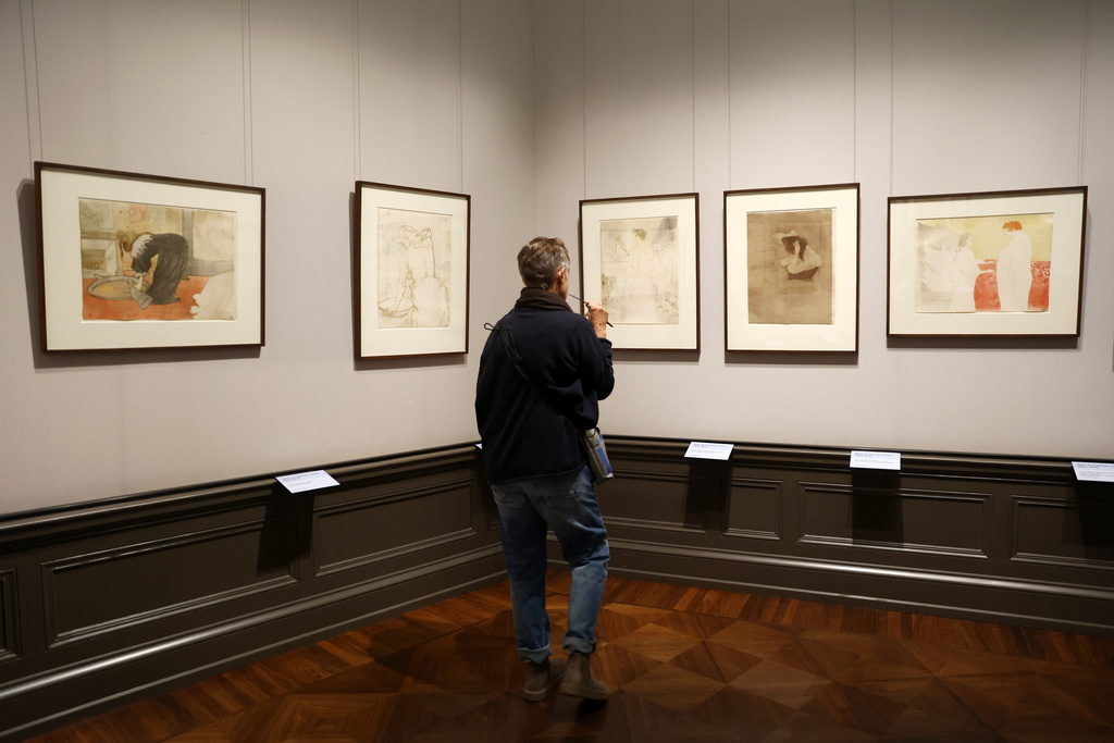 A visitor looks on the painting titled "Woman with Hand Mirror, plate 6 " from 1864-1901 by Henri de Toulouse-Lautrec at a press preview for the exhibition "The Scharf Collection: Goya – Monet – Cezanne – Bonnard – Grosse" at the Alte Nationalgalerie museum in Berlin, Wednesday, Oct. 22, 2025. (AP Photo/Maryam Majd)