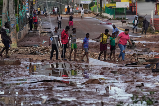 People walk through Santa Cruz, Jamaica, Wednesday, Oct. 29, 2025, after Hurricane Melissa passed. (AP Photo/Matias Delacroix), People walk through Santa Cruz, Jamaica, Wednesday, Oct. 29, 2025, after Hurricane Melissa passed. (AP Photo/Matias Delacroix),