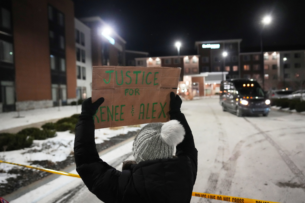 FILE - A demonstrator holds a sign reading "Justice for Renee & Alex" during a protest outside a SpringHill Suites and Residence Inn by Marriott hotels, Jan. 26, 2026, in Maple Grove, Minn. (AP Photo/Adam Gray, File)