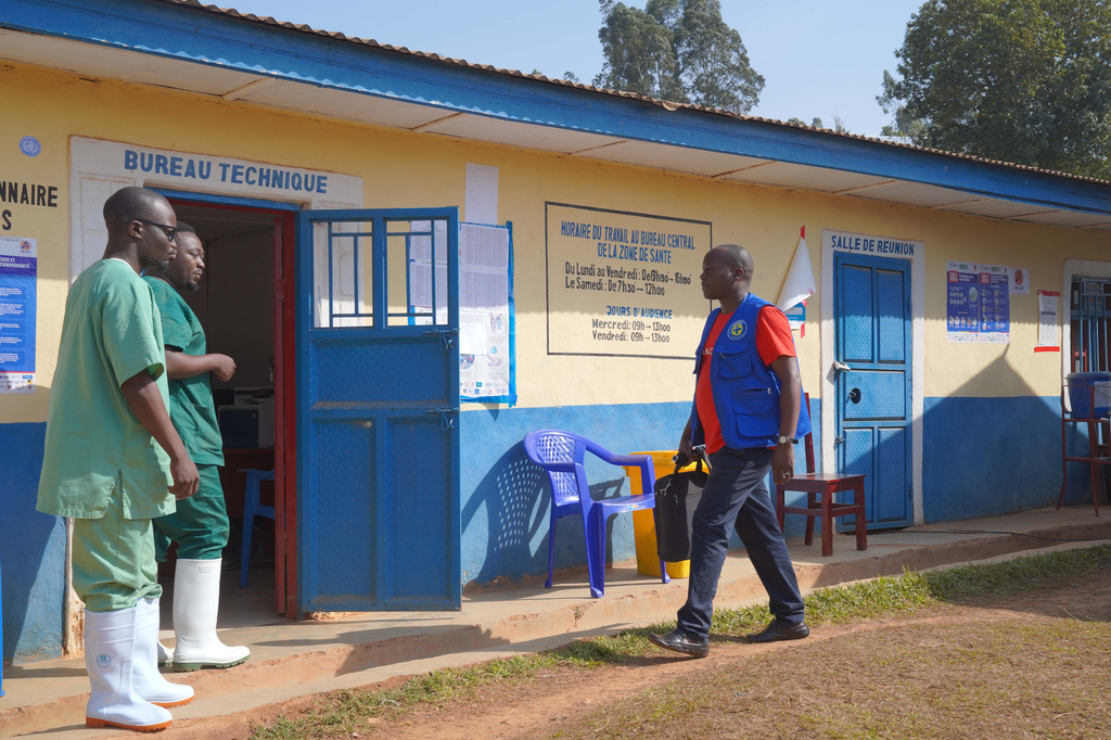 Gédéon Banga Ngbape, right, an Ebola surveillance officer, arrives at his office in Nizi, Ituri province, eastern Congo, Friday, Aug. 14, 2026. (AP Photo/Dieudonne Dirole)