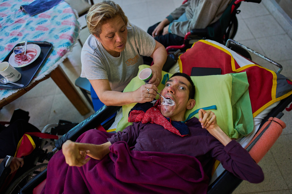 Employee Nancy Bravo feeds resident Miguel Rojas in the Pequeño Cottolengo Don Orione, a home for people with disabilities that will be visited by Pope Leo XIV in November, in Buenos Aires, Argentina, Thursday, Sept. 24, 2026. (AP Photo/Rodrigo Abd)