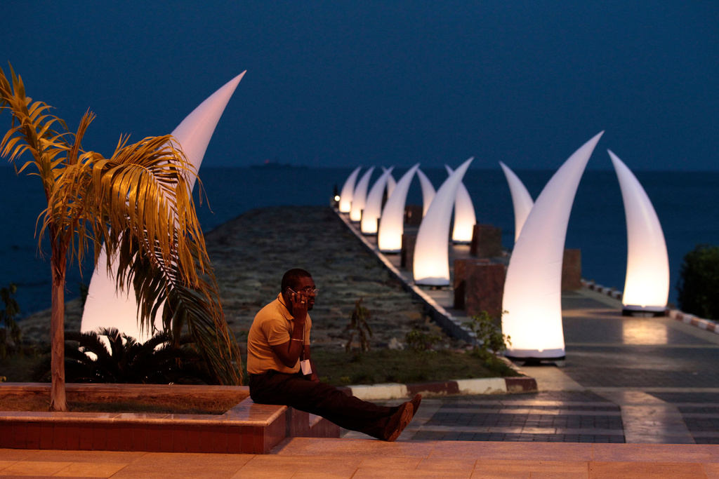 FILE - A visitor talks on his cell phone beside a jetty in Sipopo, a luxury complex constructed to host the 17th African Union Summit, outside Malabo, Equatorial Guinea, June 28, 2011. (AP Photo/Rebecca Blackwell, File)