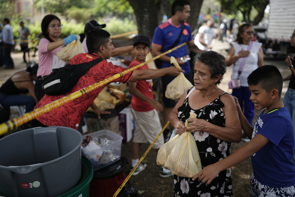 People affected by the earthquake receive food packages in Cali, Colombia, Wednesday, Aug. 12, 2026. (AP Photo/Ivan Valencia)