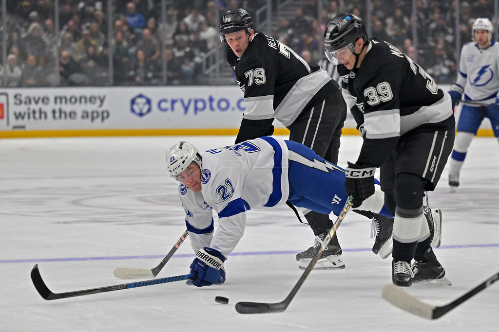 Tampa Bay Lightning center Brayden Point is tripped up by Los Angeles Kings left wing Jeff Malott (39) as they go for the puck during the first period of an NHL hockey game Thursday, Jan. 1, 2026, in Los Angeles. (AP Photo/Jayne Kamin-Oncea)