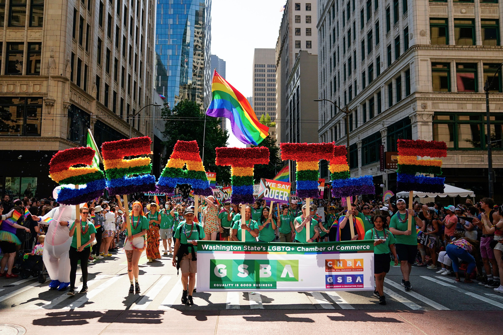 FILE - Marchers with the Greater Seattle Business Association, Washington State's LGBTQ+ and allied chamber of commerce, hold rainbow letters spelling out "Seattle," during the annual Seattle Pride Parade, June 25, 2023, in Seattle. (AP Photo/Lindsey Wasson, File)