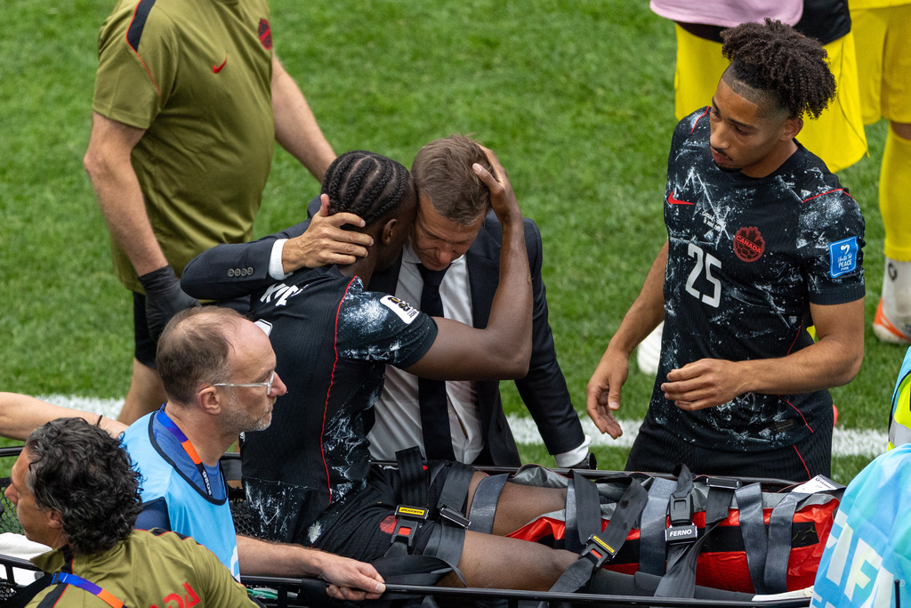 Canada head coach Jesse Marsch embraces Ismael Kone (8) as he is stretchered off the field after an injury during the World Cup Group B soccer match between Canada and Qatar in Vancouver, British Columbia, Thursday, June 18, 2026. (Timothy Matwey/The Canadian Press via AP)