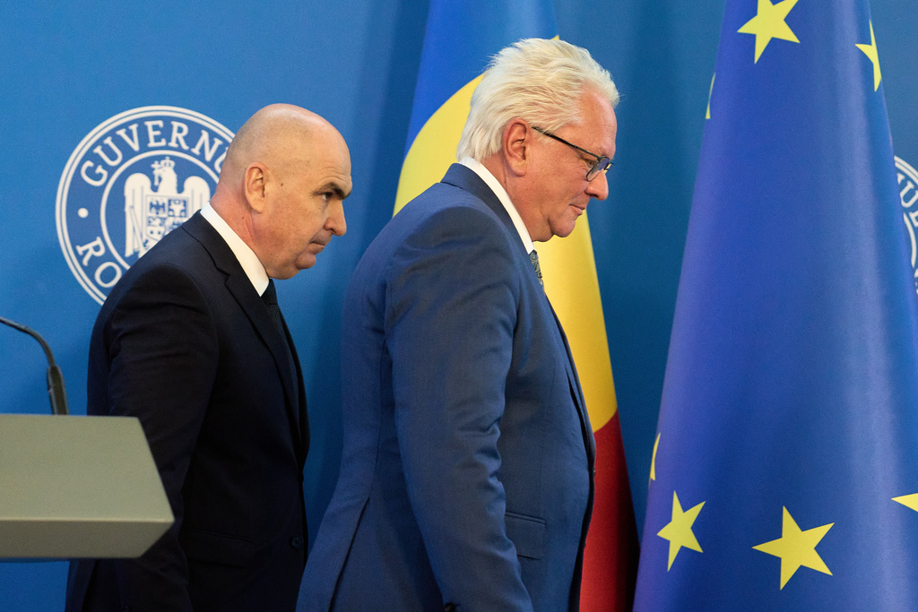 Romanian Prime Minister Ilie Bolojan, left, and Germany's Rheinmetall AG CEO Armin Papperger leave after a joint press statement in Bucharest, Romania, Monday, Nov. 3, 2025, following the signing a partnership to build an ammunition powder factory. (AP Photo/Vadim Ghirda)