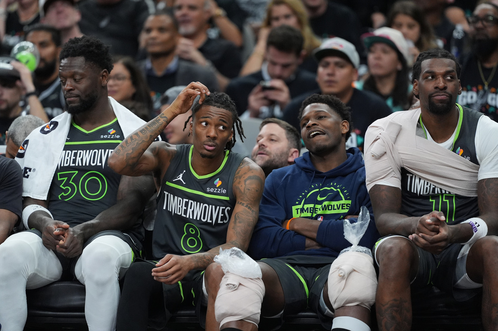 Minnesota Timberwolves forward Julius Randle (30), guard Bones Hyland (8), guard Anthony Edwards (5) and center Naz Reid (11) watch from the bench during the second half in Game 2 of a second-round NBA playoffs basketball series against the San Antonio Spurs in San Antonio, Wednesday, May 6, 2026. (AP Photo/Eric Gay)