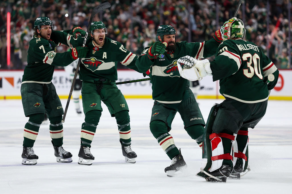 Minnesota Wild players celebrate after their team's win over the Dallas Stars during overtime of Game 4 in the first round of the NHL Stanley Cup hockey playoffs Saturday, April 25, 2026, in St. Paul, Minn. (AP Photo/Matt Krohn)
