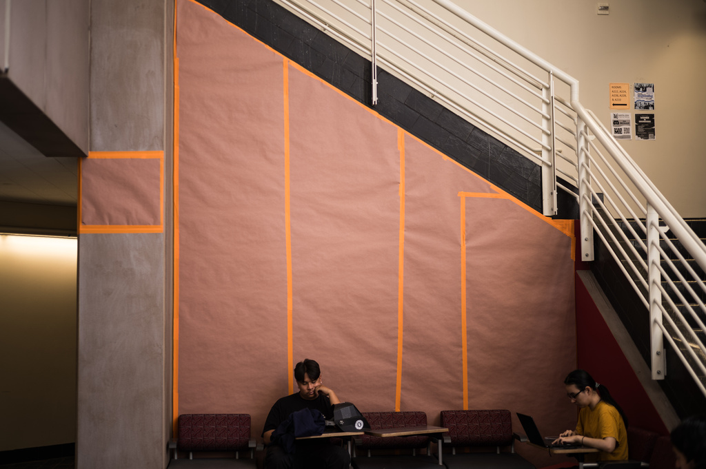 Students sit in front of a covered mural of Cesar Chavez at Santa Ana College in Santa Ana, Calif., Thursday, March 19, 2026. (AP Photo/Jae C. Hong)