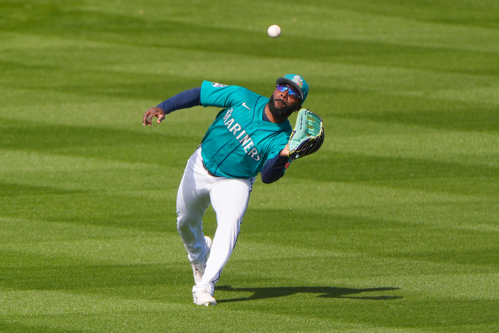 Seattle Mariners left fielder Randy Arozarena catches a fly ball for the out on San Diego Padres left fielder Nick Schnell during the second inning of a spring training baseball game Friday, Feb. 20, 2026, in Peoria, Ariz. (AP Photo/Charlie Riedel)