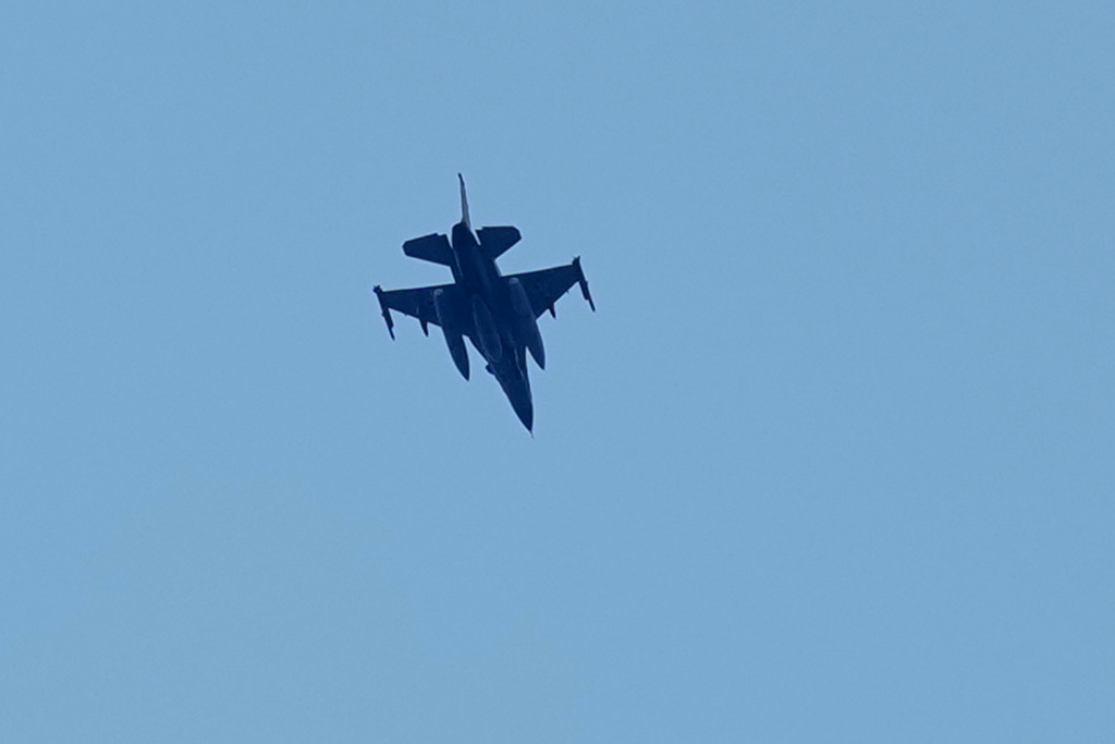 An Israeli warplane flies over the city of Tyre, south Lebanon, Wednesday, March 25, 2026. (AP Photo/Hussein Malla)