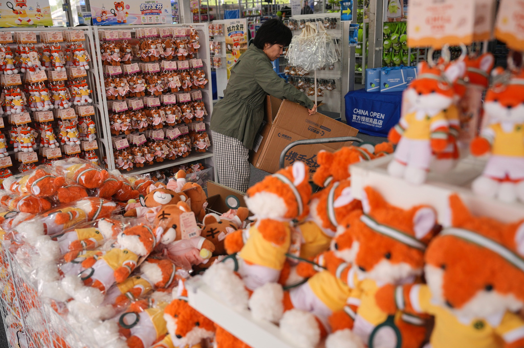 A worker stocks up plush toys for sale at a souvenir store during the China Open tennis championships in Beijing, Wednesday, Sept. 30, 2026. (AP Photo/Andy Wong)