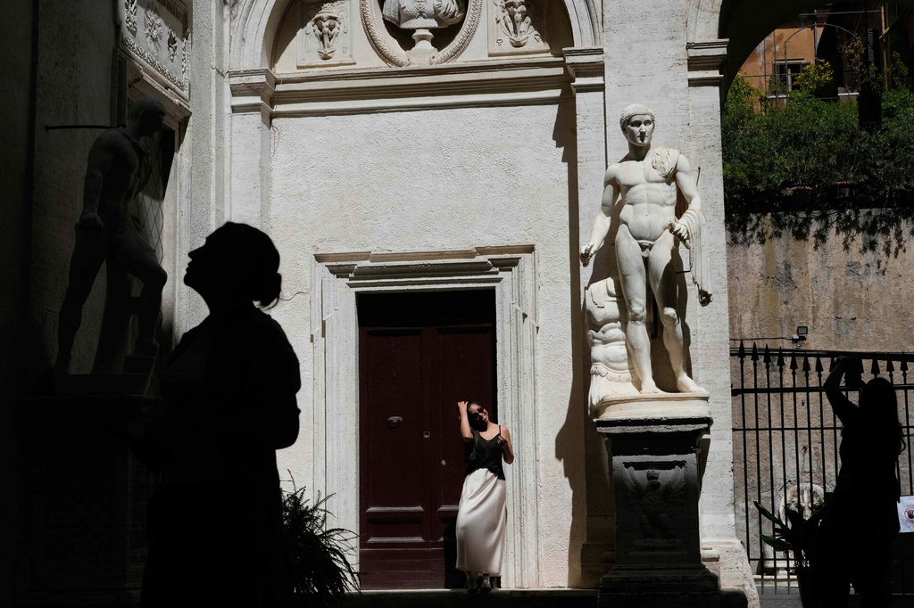 Tourists visit the American Studies center courtyard adorned with Ancient Roman statues, in Rome, Thursday, April 16, 2026. (AP Photo/Gregorio Borgia)