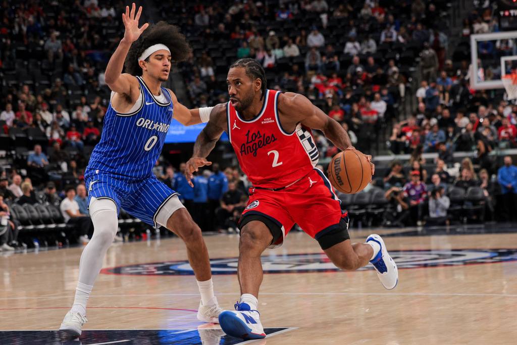 Los Angeles Clippers forward Kawhi Leonard, right, dribbles past Orlando Magic guard Anthony Black during the second half of a NBA basketball game, Sunday, Feb. 22, 2026, in Inglewood, Calif. (AP Photo/Etienne Laurent)