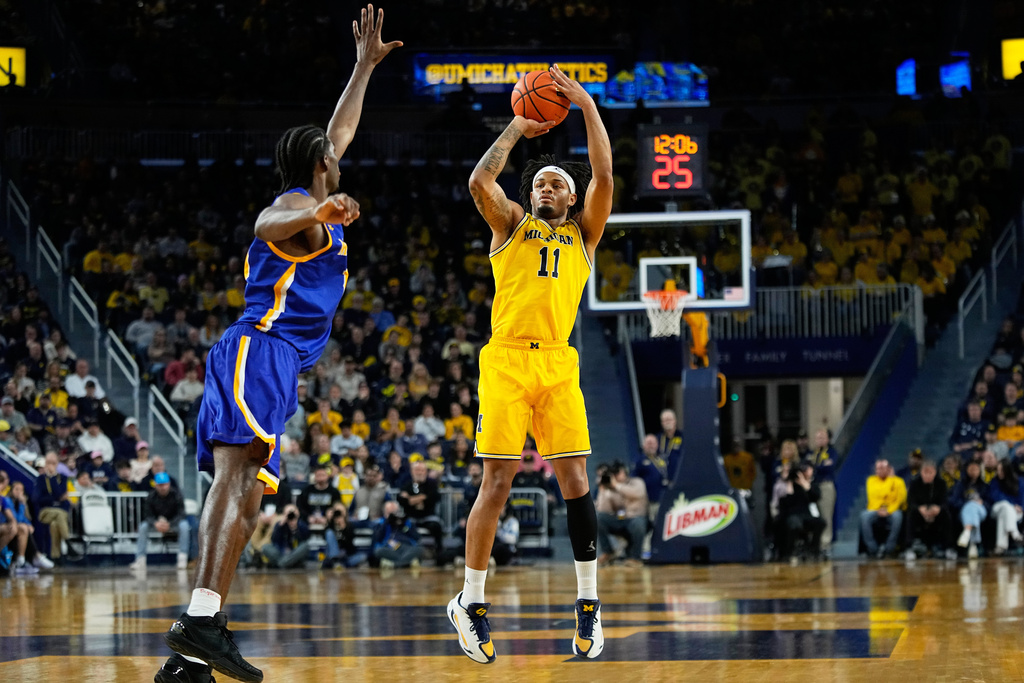 Michigan guard Roddy Gayle Jr., right, shoots against McNeese forward Jacolb Fredson-Cole during the second half of an NCAA college basketball game Monday, Dec. 29, 2025, in Ann Arbor, Mich. (AP Photo/Ryan Sun)