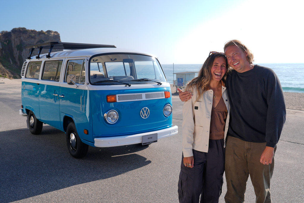 Megan Krystle Weinraub, left, and Preston Martin, who is the former owner, pose in front of her Volkswagen bus after seeing it for the first time Monday, Oct. 27, 2025, in Malibu, Calif., after it was restored by VW. (AP Photo/Mark J. Terrill)