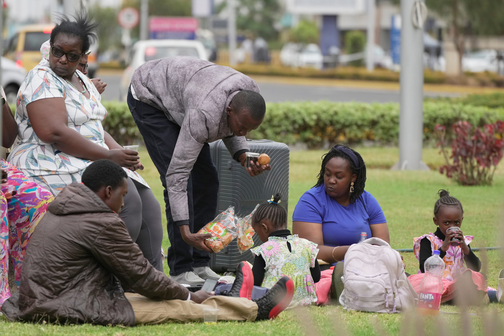 Passengers eat as they wait for their delayed flights at Jomo Kenyatta International Airport (JKIA) in Nairobi, Kenya, Monday, Feb. 16, 2026. (AP Photo/Brian Inganga)