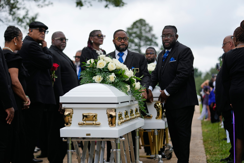 The caskets of the eight children who were killed during a mass shooting last month, arrive for burial Saturday, May 9, 2026, at Forest Park Cemetery West in Shreveport, La. (AP Photo/Gerald Herbert)