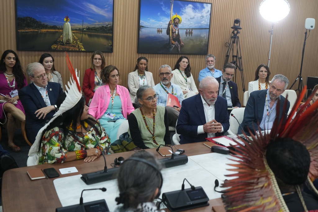 Brazil President Luiz Inacio Lula da Silva, second from right, sits with Brazil Indigenous Peoples Minister Sonia Guajajara, left, Marina Silva, Brazil environment minister, second from left, and André Corrêa do Lago, COP30 president, right, as they speak with members from Indigenous groups at the COP30 U.N. Climate Summit, Wednesday, Nov. 19, 2025, in Belem, Brazil. (AP Photo/Andre Penner)