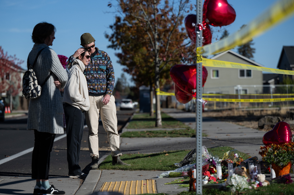 From right, Kyle Ketchum embraces Christina Edwards at a makeshift memorial outside Silver Rail Elementary in Bend, Ore., Friday, Oct. 16, 2026, a day after a deadly shooting. (AP Photo/Joe Kline)