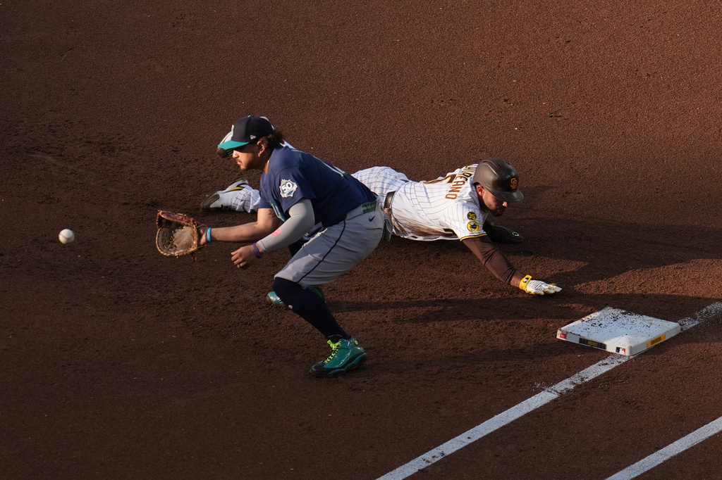 San Diego Padres' Ramón Laureano, right, gets back to first base in time as Seattle Mariners first baseman Josh Naylor awaits the throw during the first inning of a baseball game Thursday, April 16, 2026, in San Diego. (AP Photo/Gregory Bull)