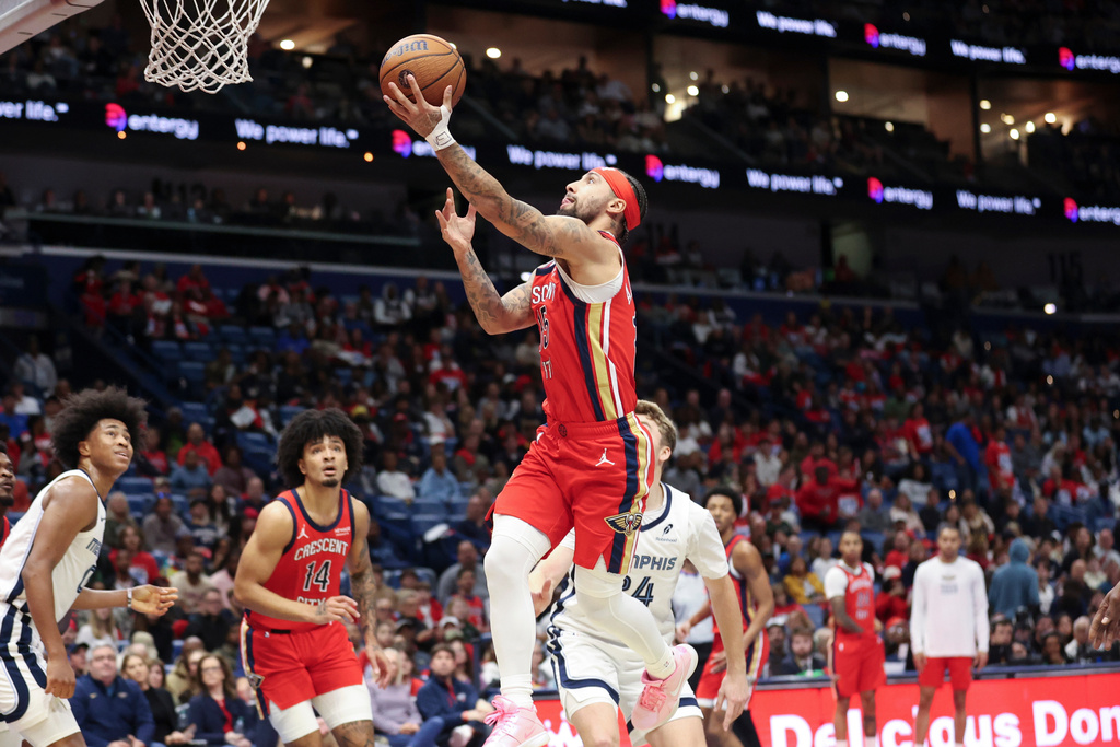 New Orleans Pelicans guard Jose Alvarado drives past Memphis Grizzlies guard Cam Spencer for a layup in the first half of an Emirates NBA Cup basketball game, Wednesday, Nov. 26, 2025, in New Orleans. (AP Photo/Peter Forest)