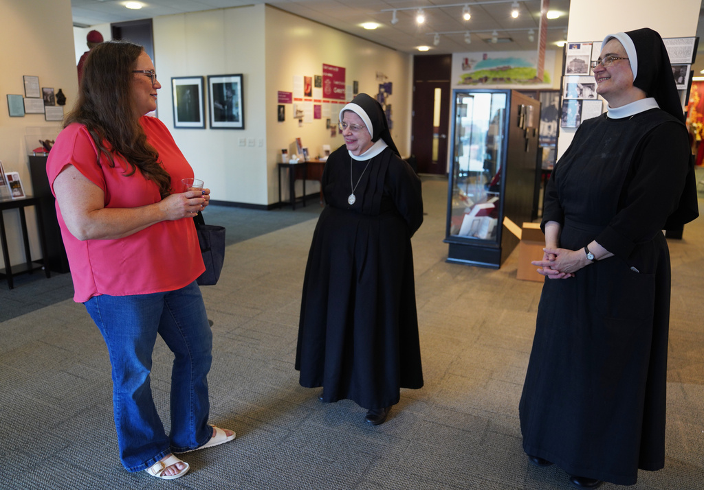 Bonnie Engstrom talks with two sisters at the Archbishop Fulton Sheen Museum in Peoria, Ill., on July 16, 2026. (AP Photo/Jessie Wardarski)
