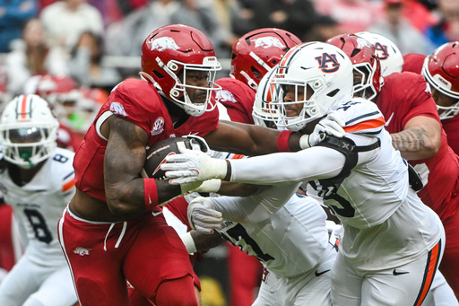 Arkansas running back Mike Washington Jr., left, tries to run past Auburn defender Preston Howard (15) during the first half of an NCAA college football game Saturday, Oct. 25, 2025, in Fayetteville, Ark. (AP Photo/Michael Woods) Arkansas running back Mike Washington Jr., left, tries to run past Auburn defender Preston Howard (15) during the first half of an NCAA college football game Saturday, Oct. 25, 2025, in Fayetteville, Ark. (AP Photo/Michael Woods)