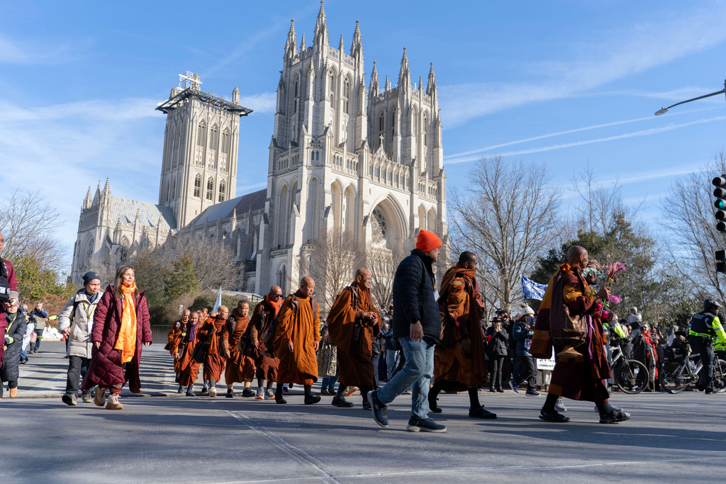 Buddhist monks walk outside of the Washington National Cathedral after and event they participated during the Walk For Peace, Tuesday, Feb. 10, 2026, in Washington. (AP Photo/Jose Luis Magana)
