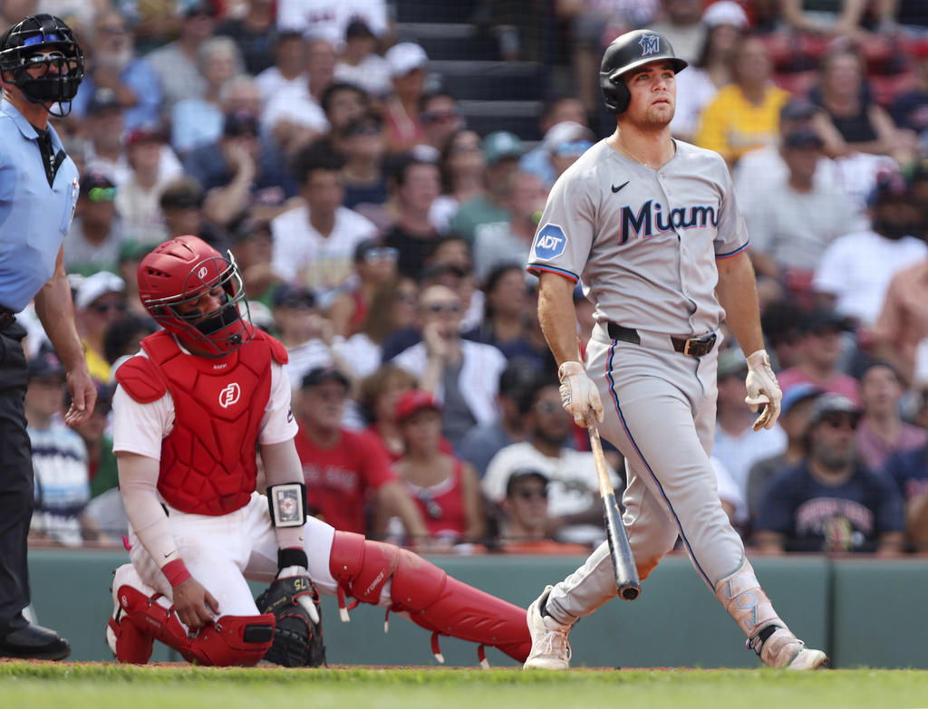 The Miami Marlins' Jakob Marsee, right, watches the flight of his two-run home run in the ninth inning, while Boston Red Sox's catcher Carlos Narvaez reacts at left during a baseball game, Sunday Aug.17, 2025 in Boston. (AP Photo/Jim Davis)