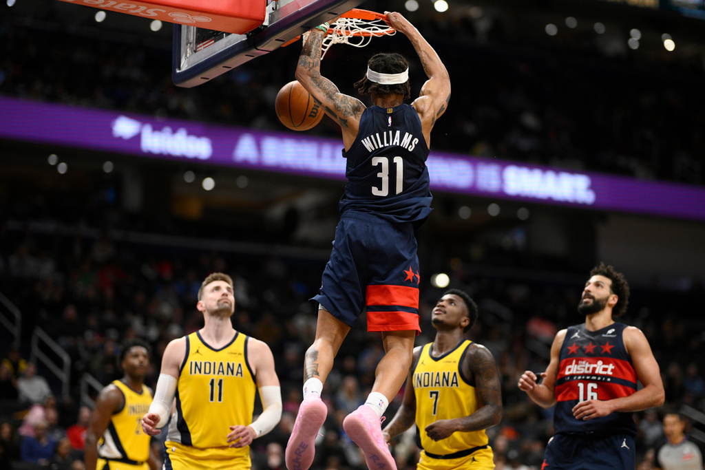 Washington Wizards guard Alondes Williams (31) dunks over Indiana Pacers center Micah Potter (11) and guard Kam Jones (7) during the second half of an NBA basketball game, Friday, Feb. 20, 2026, in Washington. (AP Photo/Nick Wass)