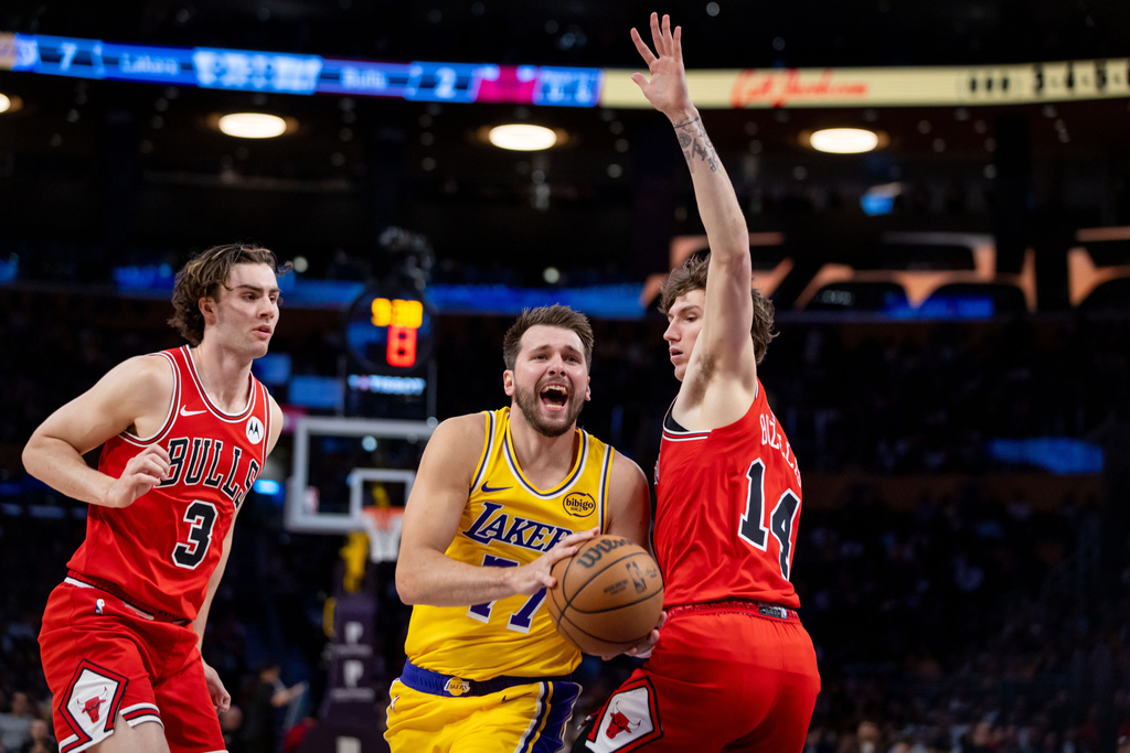 Los Angeles Lakers guard Luka Doncic (77) goes to the basket against Chicago Bulls guard Josh Giddey (3) and Chicago Bulls forward Matas Buzelis (14) during the first half of an NBA basketball game against the Chicago Bulls, Thursday, March 12, 2026, in Los Angeles. (AP Photo/Ethan Swope)