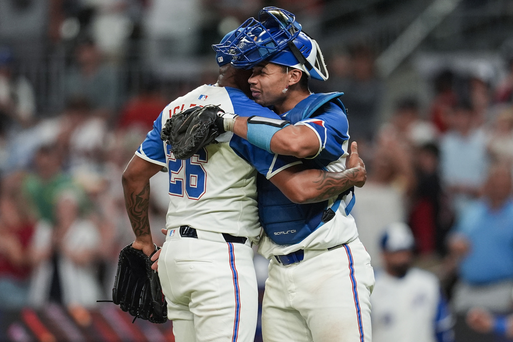 Atlanta Braves pitcher Raisel Iglesias (26) and catcher Drake Baldwin (30) celebrate a win over the Miami Marlins after the second baseball game of a doubleheader, Saturday, Aug. 9, 2025, in Atlanta. (AP Photo/Mike Stewart)