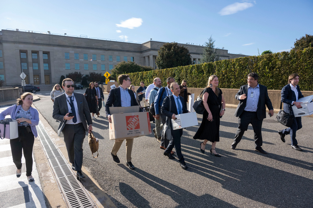 Members of the Pentagon press corp carry their belongings out of the Pentagon after turning in their press credentials, Wednesday, Oct. 15, 2025 in Washington. (AP Photo/Kevin Wolf)