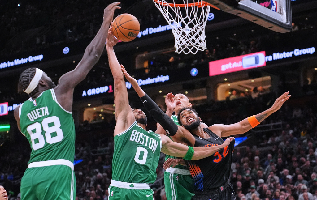 New York Knicks' Karl-Anthony Towns (32) battles for a rebound against the Boston Celtics during the second half of an NBA basketball game, Friday, Oct. 23, 2026, in Boston. (AP Photo/Charles Krupa)