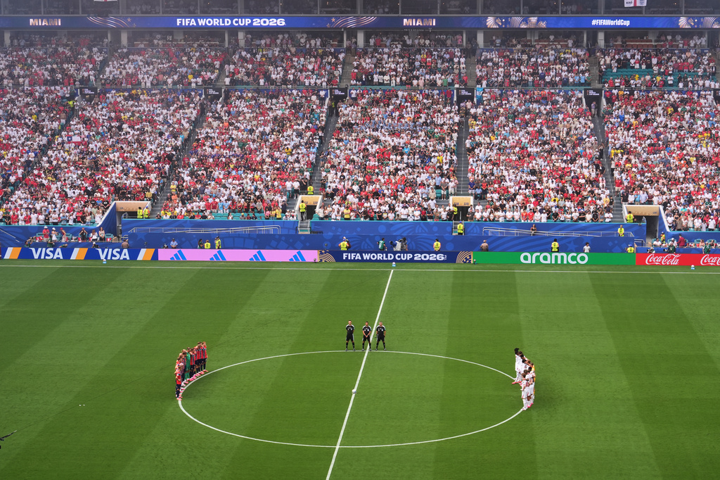 Players, officials and fans stand for a moment of silence for South Africa's Jayden Adams during the World Cup quarterfinal soccer match between Norway and England in Miami Gardens, Fla., Saturday, July 11, 2026. (AP Photo/Marta Lavandier)