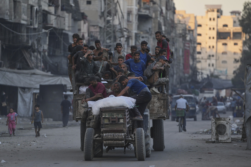 Palestinians ride on a truck carrying humanitarian aid collected from the northern Gaza Strip, as it moves along a street in Gaza City, Friday, Aug. 29, 2025. (AP Photo/Jehad Alshrafi)